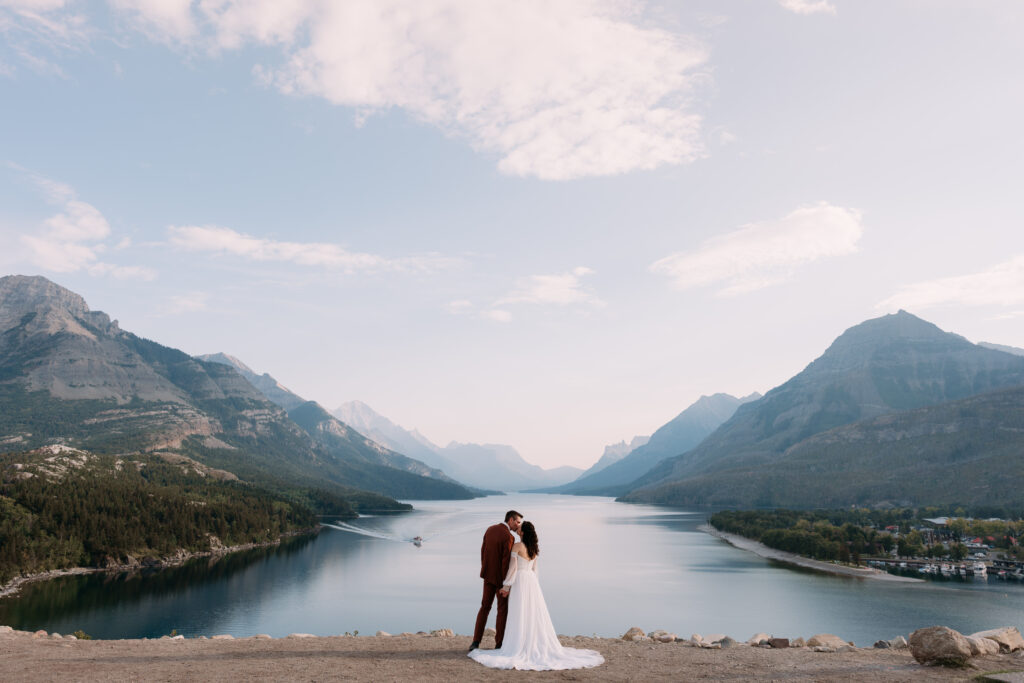 couple kisses in front of lake on the prince of wales hill during waterton elopement
