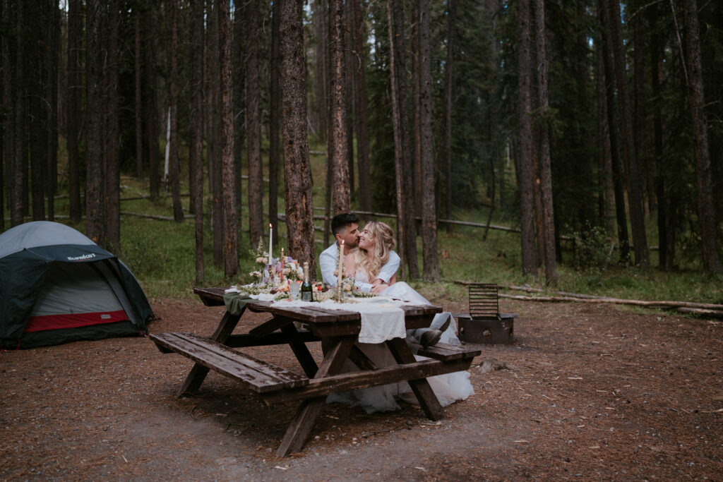 Couple has fancy picnic in campsite during elopement at Two Jack Lake campground