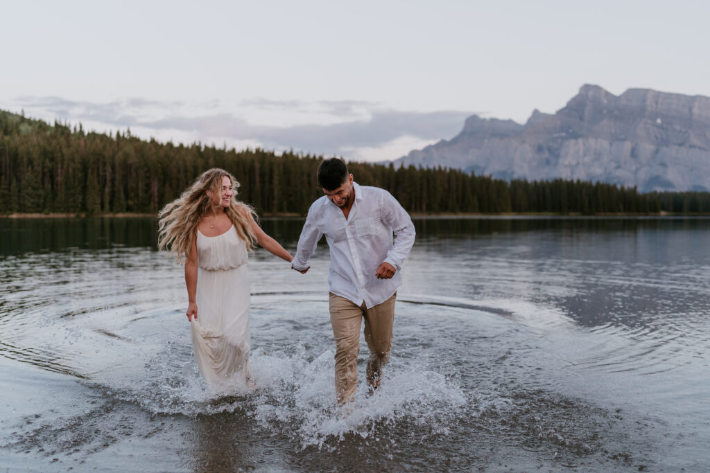 Couple runs in water during elopement in Banff National Park