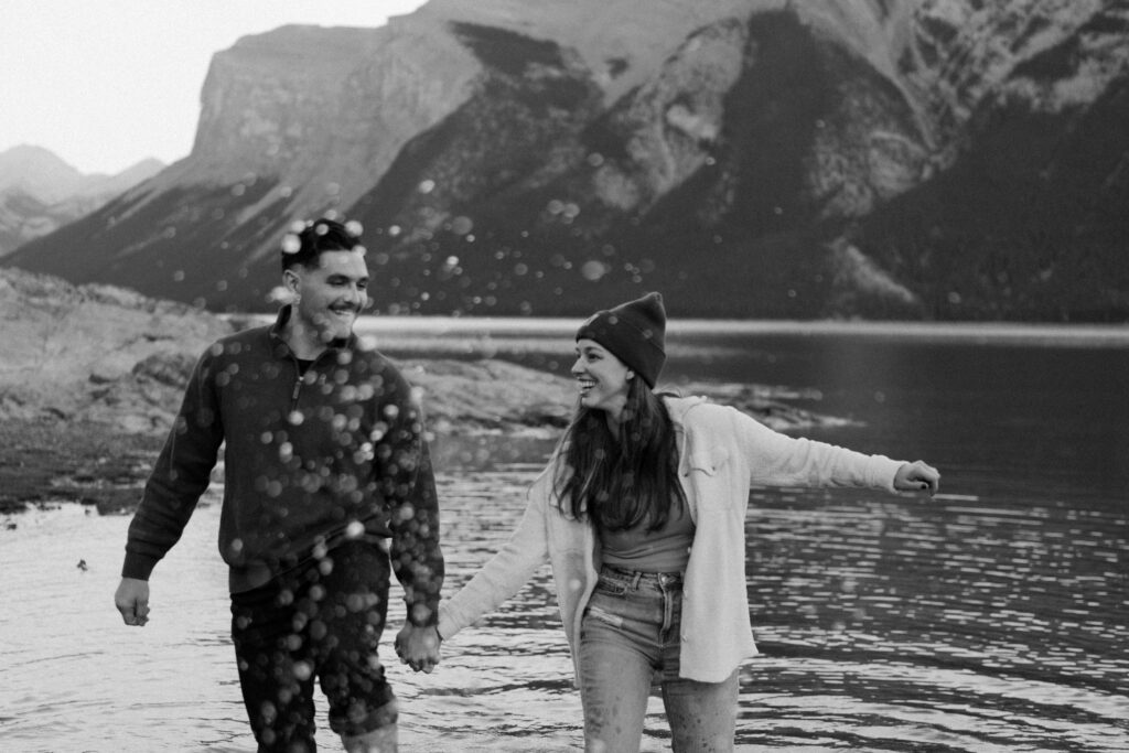 couple splashes in water at lake minnewanka