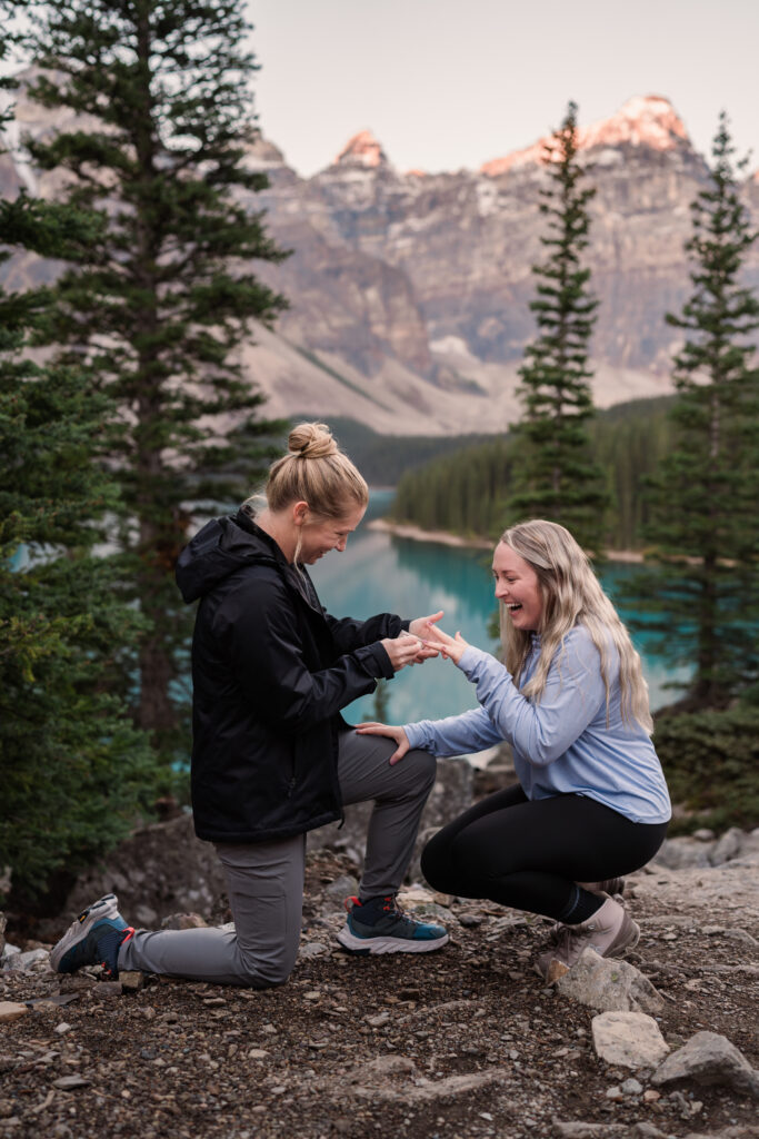 woman proposes to her girlfriend at sunrise at Moraine lake