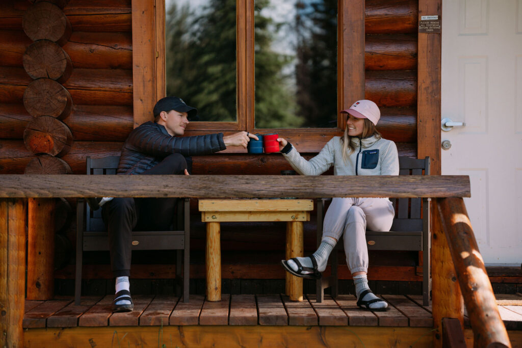 Couple drinks coffee together on the porch of their Shadow Lake Lodge cabin during elopement