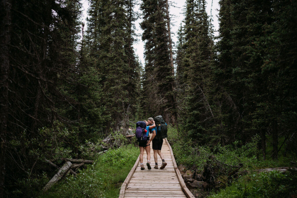 Couple walks along boardwalk heading to Shadow Lake Lodge for their elopement
