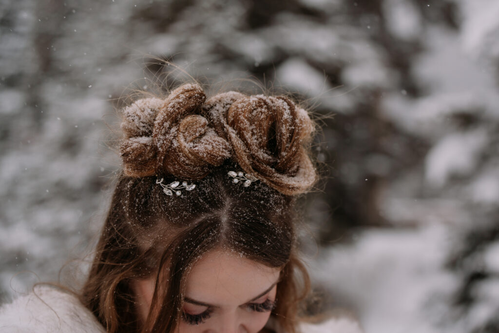 hair piece in brides hair while snow covers her space buns