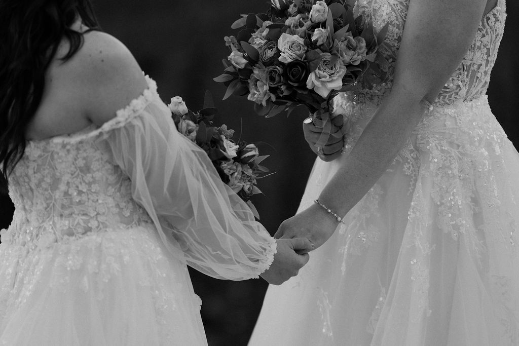 brides hold hands during ceremony