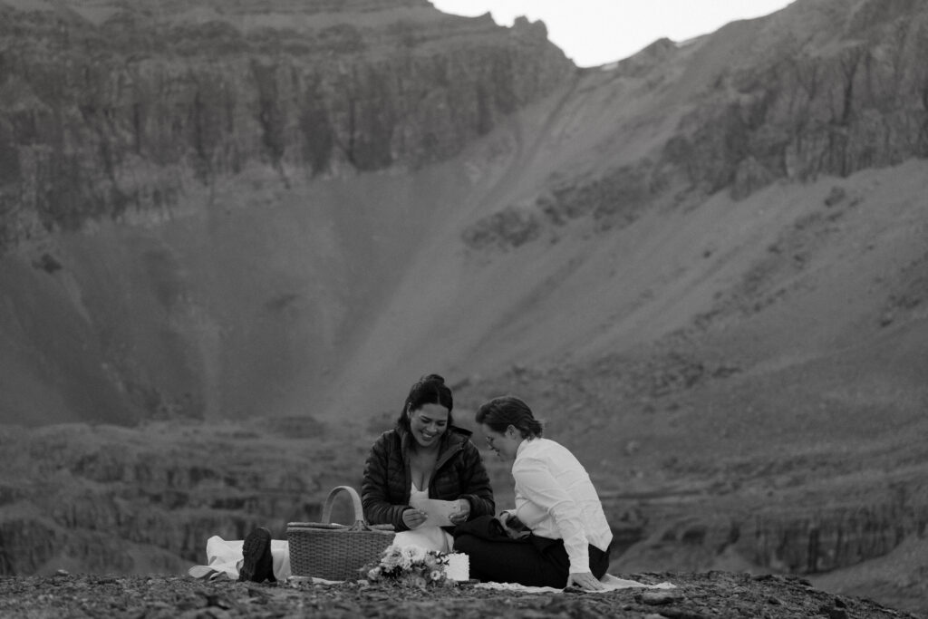 black and white of couple reading letters from family during helicopter elopement