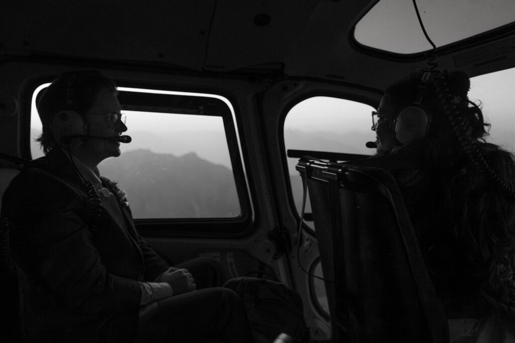 two brides look at each other in a helicopter during elopement