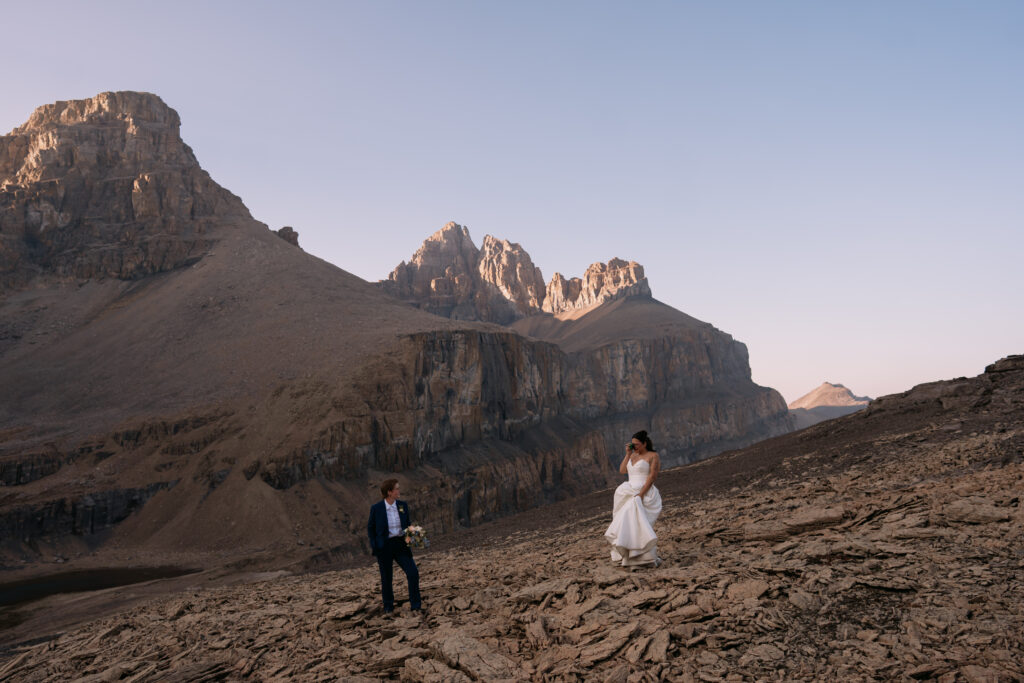 bride takes a photo of her partner with a disposable camera during Canadian Rockies heli elopement